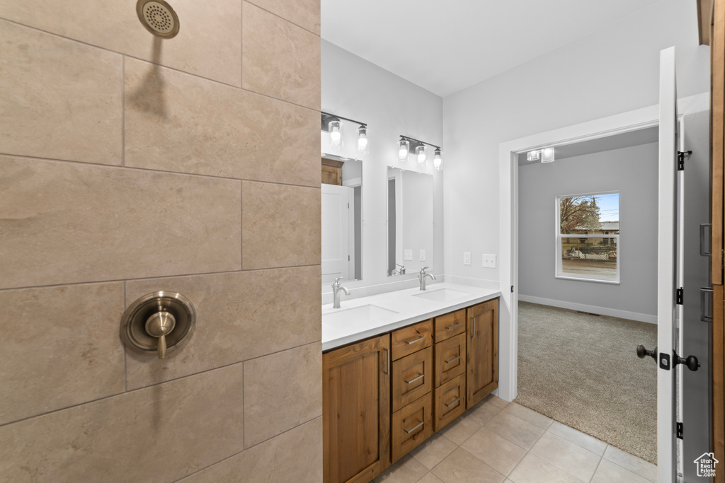 Bathroom with tile patterned floors, a sink, and double vanity