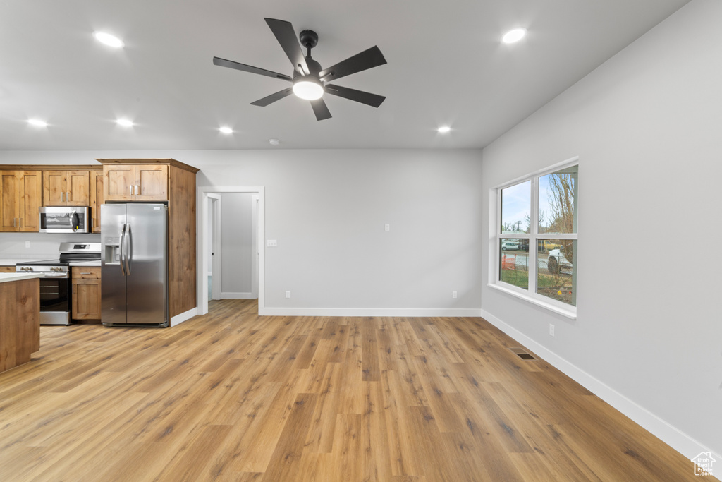 Kitchen featuring light countertops, recessed lighting, light wood-style flooring, appliances with stainless steel finishes, and brown cabinetry