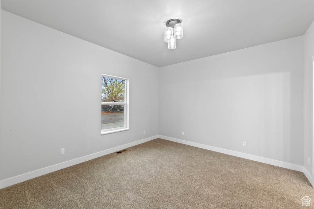 Carpeted spare room with baseboards and visible vents