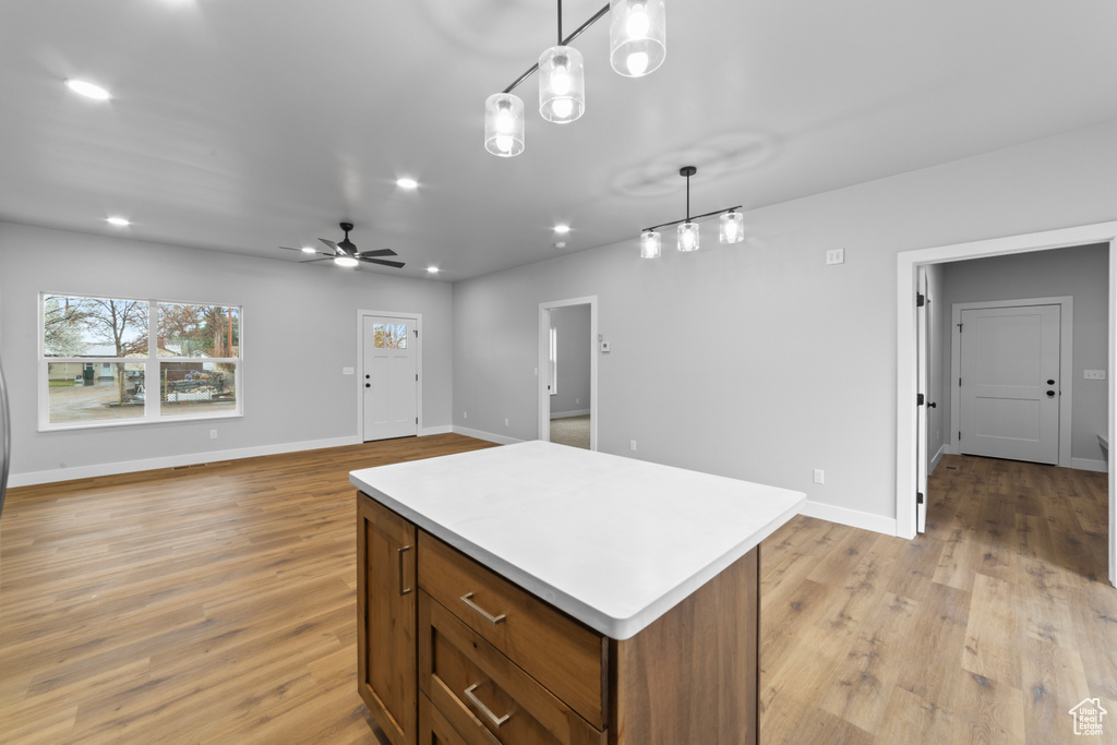 Kitchen with light wood-style floors, light countertops, recessed lighting, and a center island