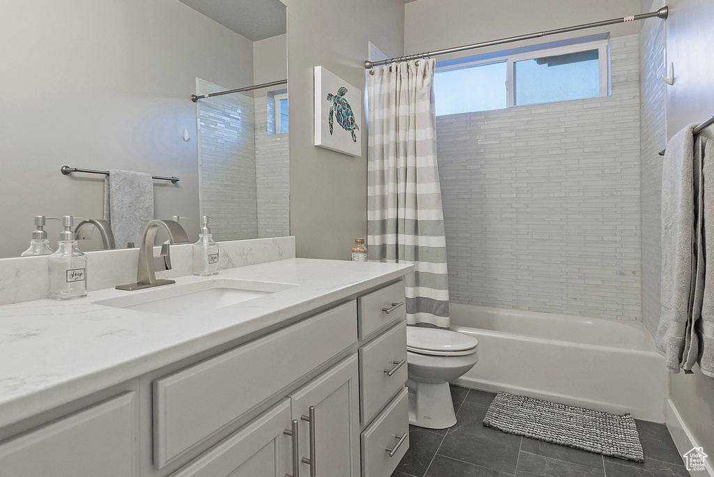 Full bath featuring tile patterned flooring, shower / bathtub combination with curtain, toilet, and vanity