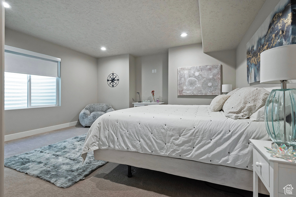 Carpeted bedroom featuring recessed lighting, baseboards, and a textured ceiling