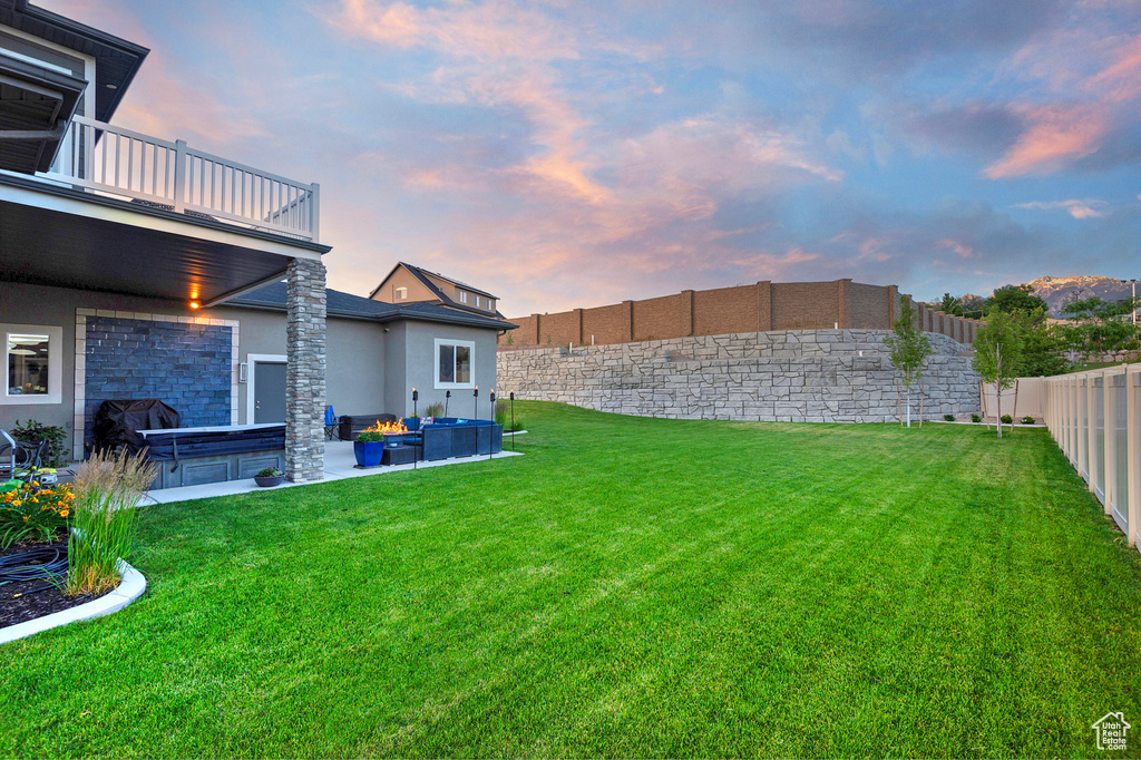 View of yard featuring a fenced backyard, a balcony, a hot tub, and a patio