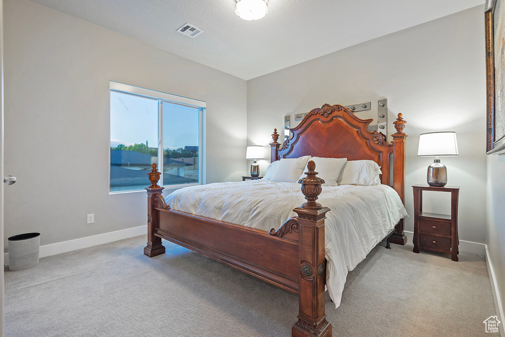 Bedroom featuring light carpet, baseboards, and visible vents