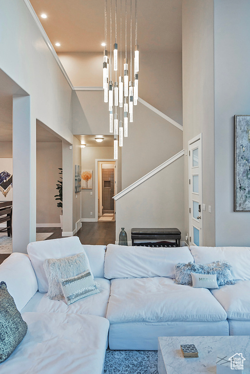 Living room with a notable chandelier, stairway, a high ceiling, baseboards, and recessed lighting