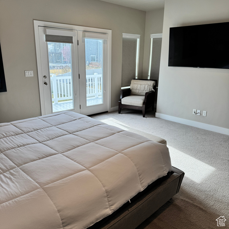 Bedroom featuring baseboards, access to outside, and light colored carpet