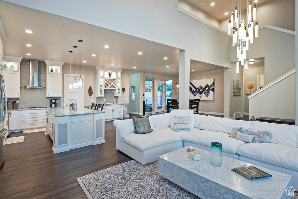 Living room featuring dark wood-style floors, baseboards, and recessed lighting