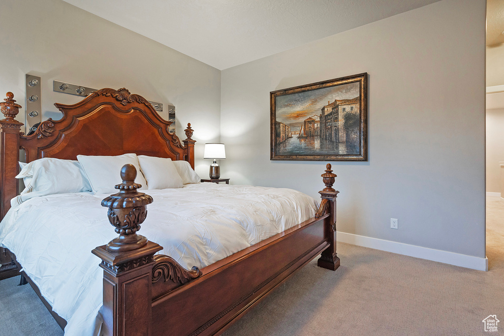 Bedroom with baseboards and light colored carpet