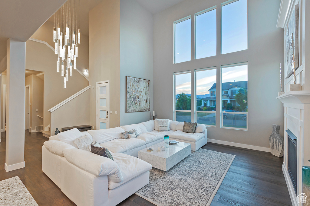 Living area with visible vents, baseboards, a fireplace, stairway, and dark wood finished floors