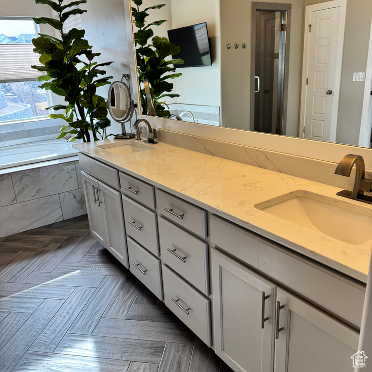 Bathroom with double vanity, a sink, a stall shower, and a bath