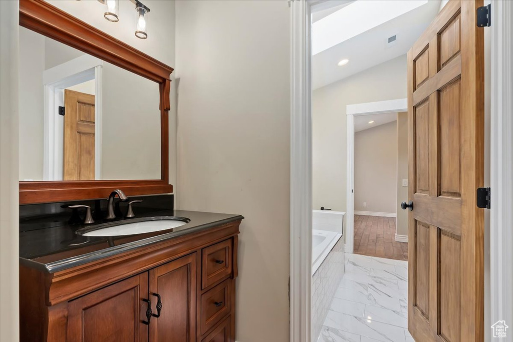 Full bathroom with vanity, recessed lighting, baseboards, marble finish floor, and a bath