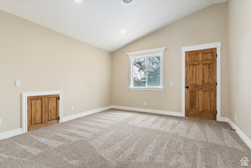 Carpeted spare room featuring baseboards, lofted ceiling, and recessed lighting