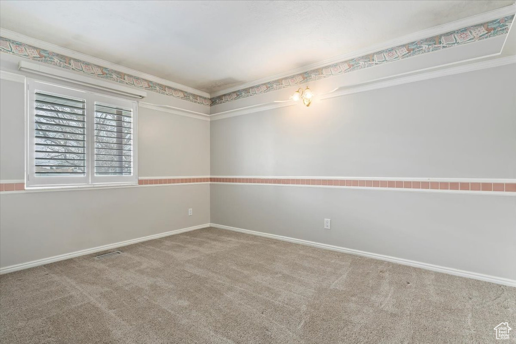 Carpeted empty room with baseboards and crown molding
