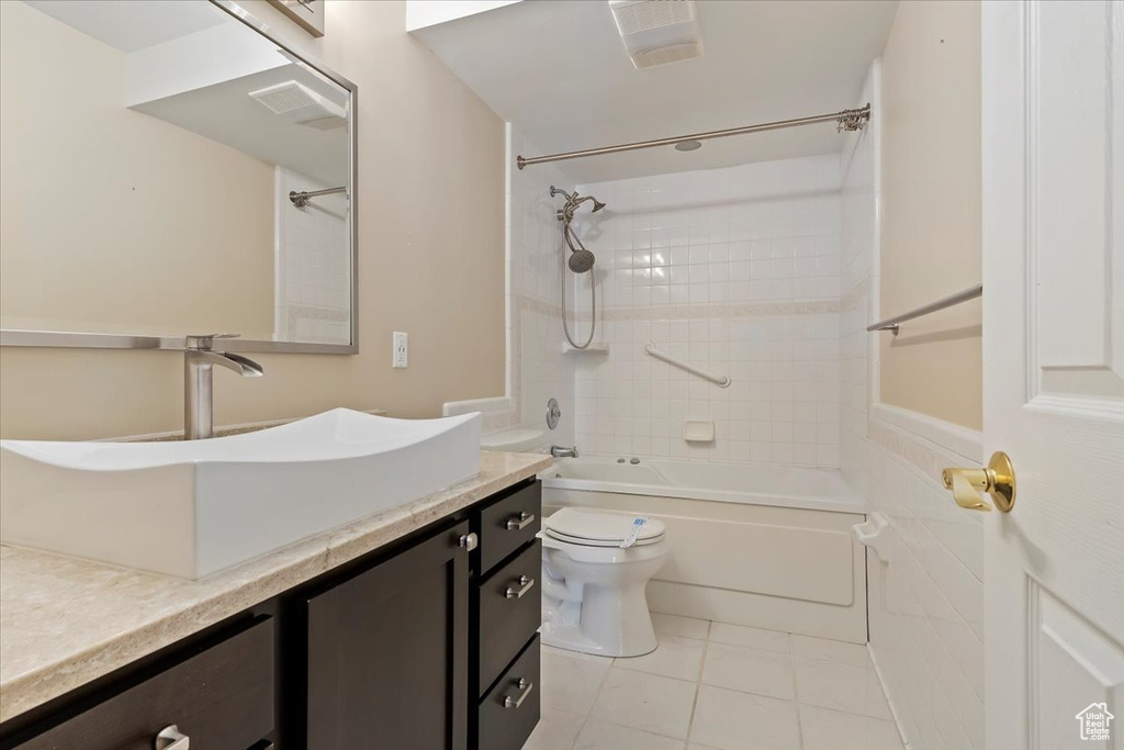 Bathroom featuring toilet, vanity,  shower combination, tile patterned flooring, and visible vents
