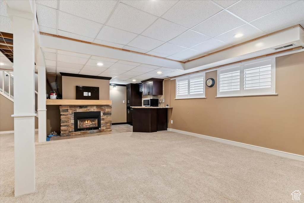 Living room featuring light carpet, baseboards, visible vents, and a fireplace