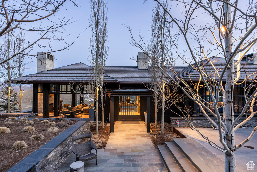 Back of house featuring a chimney and a patio area
