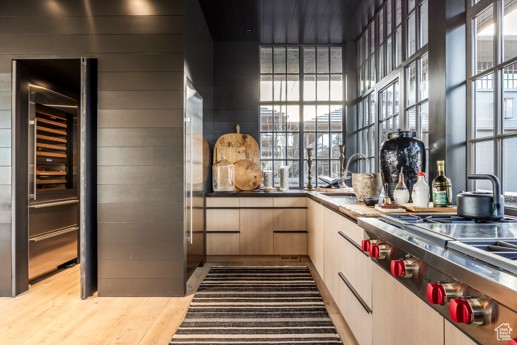 Kitchen featuring stainless steel gas cooktop, wood finished floors, and beverage cooler