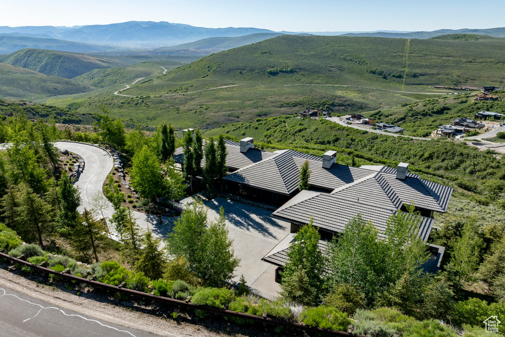 Aerial view of property and surrounding area featuring a mountain backdrop