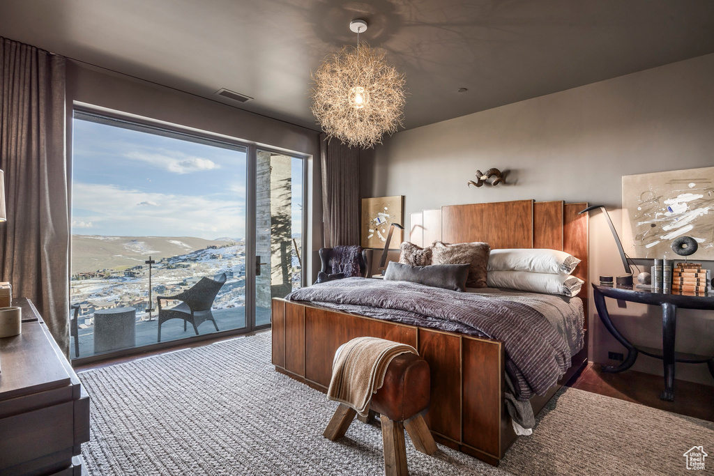 Bedroom featuring access to exterior and a chandelier