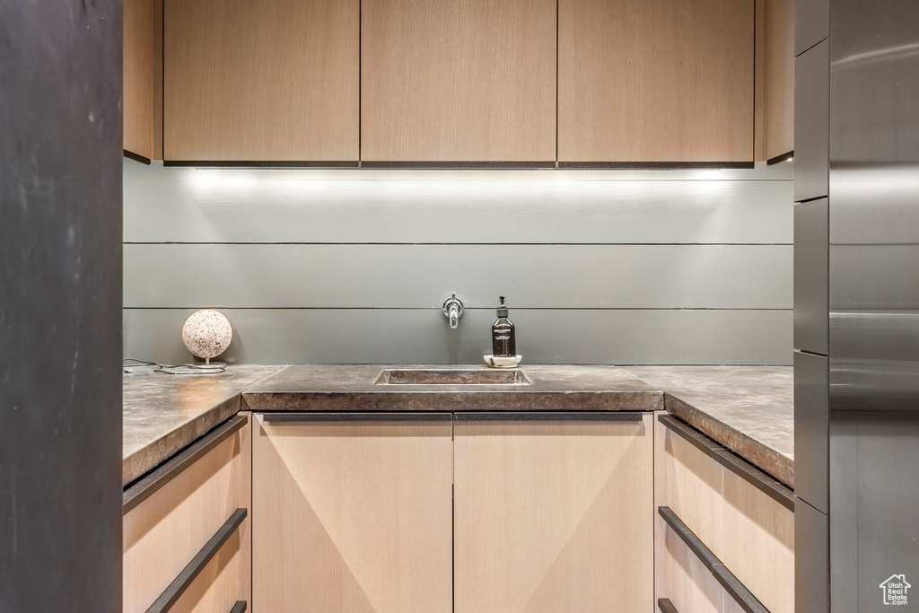 Detailed view of a sink and stainless steel fridge