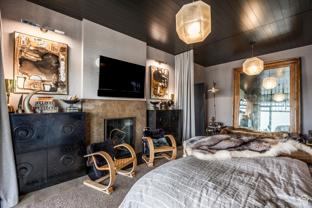 Bedroom featuring a fireplace and wood ceiling
