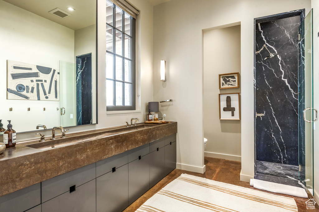 Bathroom with double vanity and a marble finish shower