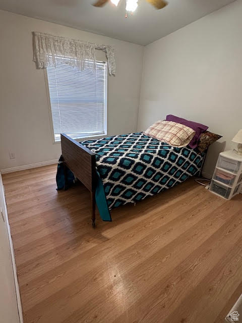 Bedroom featuring wood finished floors, ceiling fan, and baseboards