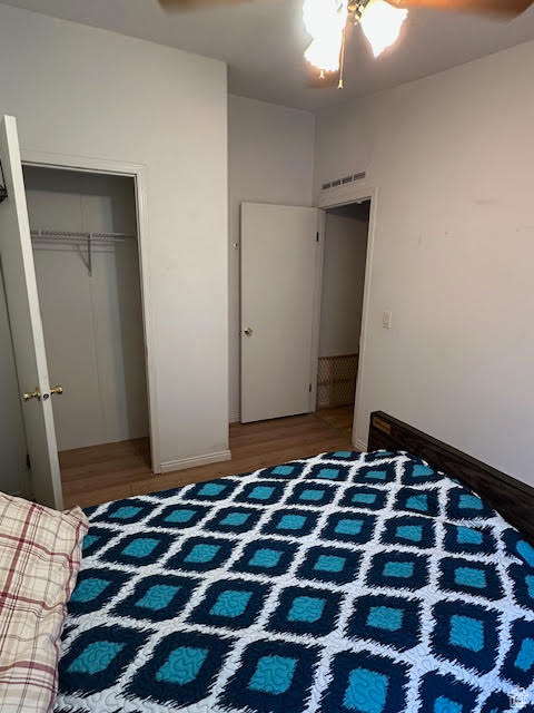 Bedroom featuring wood finished floors, a closet, and baseboards