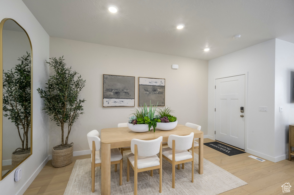 Dining area featuring baseboards, light wood-type flooring, visible vents, and recessed lighting