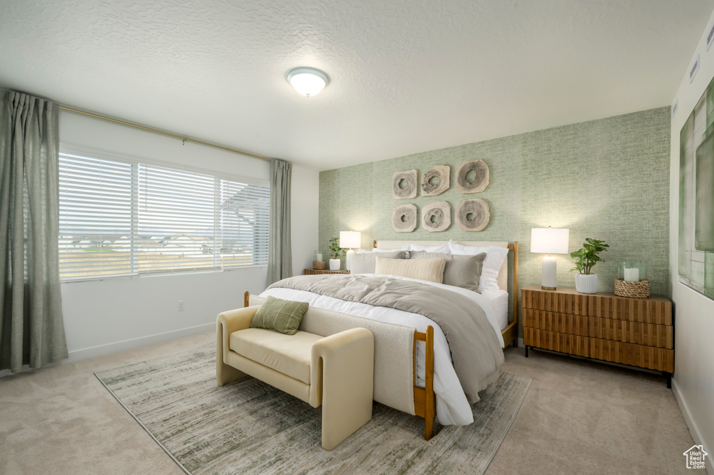 Bedroom with light colored carpet, radiator heating unit, a textured ceiling, baseboards, and wallpapered walls
