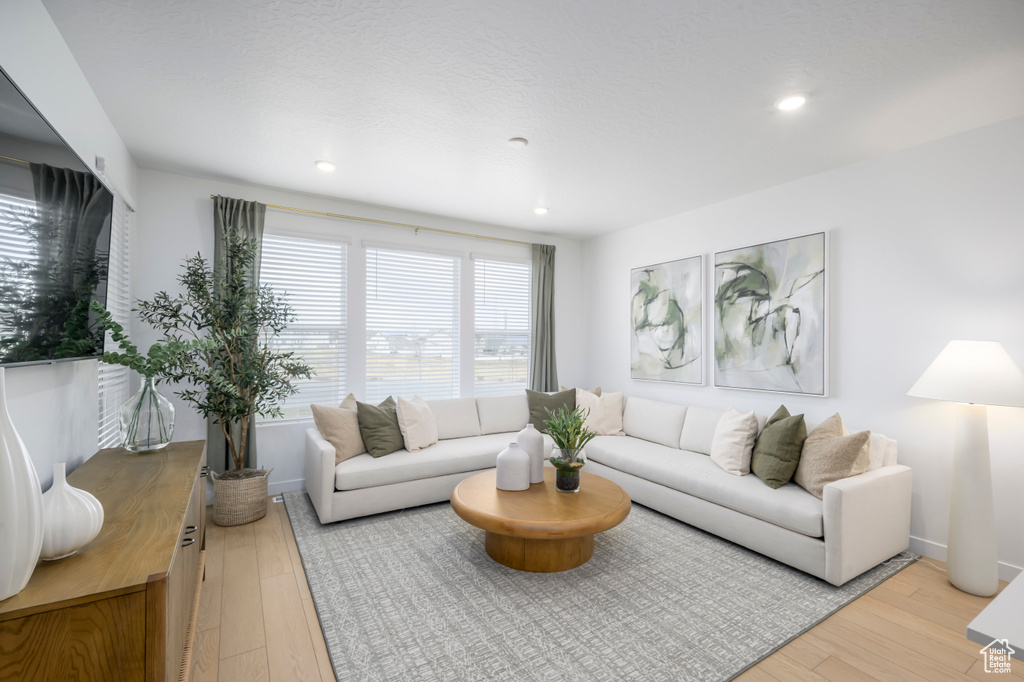 Living room featuring recessed lighting, baseboards, and light wood-type flooring