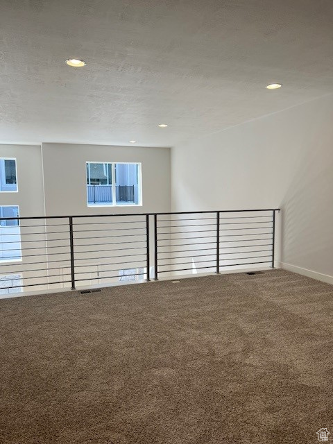 Carpeted spare room featuring baseboards and recessed lighting