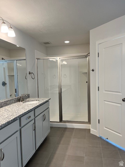 Full bath featuring vanity, visible vents, recessed lighting, a stall shower, and tile patterned flooring