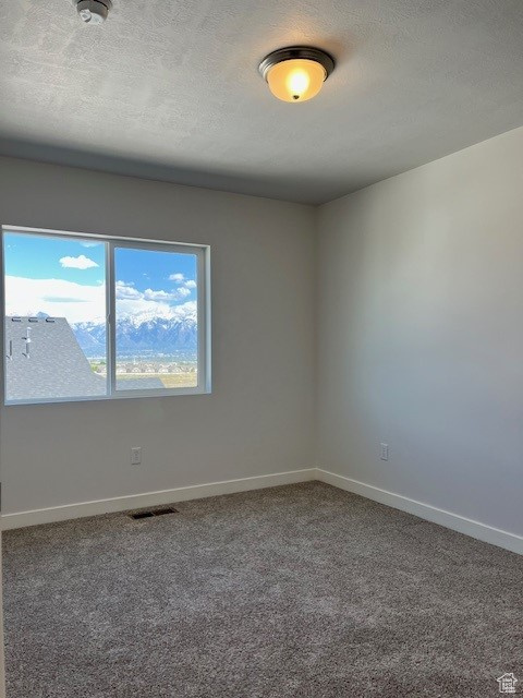 Unfurnished room featuring baseboards, carpet flooring, and visible vents