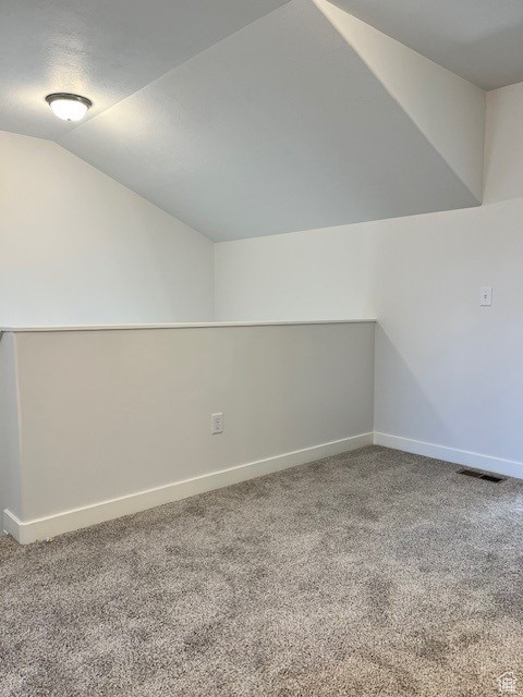 Bonus room with carpet flooring, vaulted ceiling, baseboards, and visible vents
