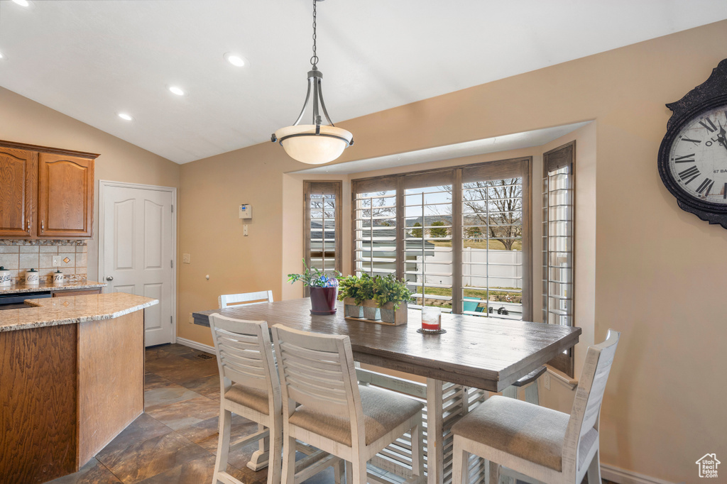 Dining area featuring recessed lighting, baseboards, lofted ceiling, and dark stone finish flooring