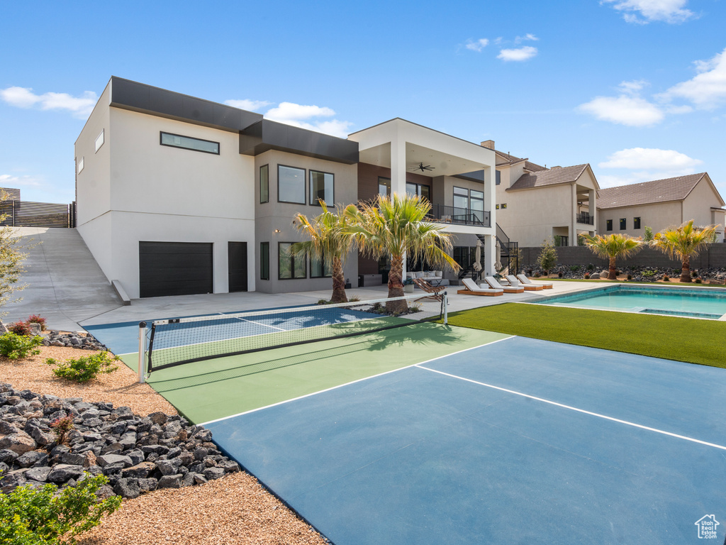 View of basketball court with a fenced in pool and fence