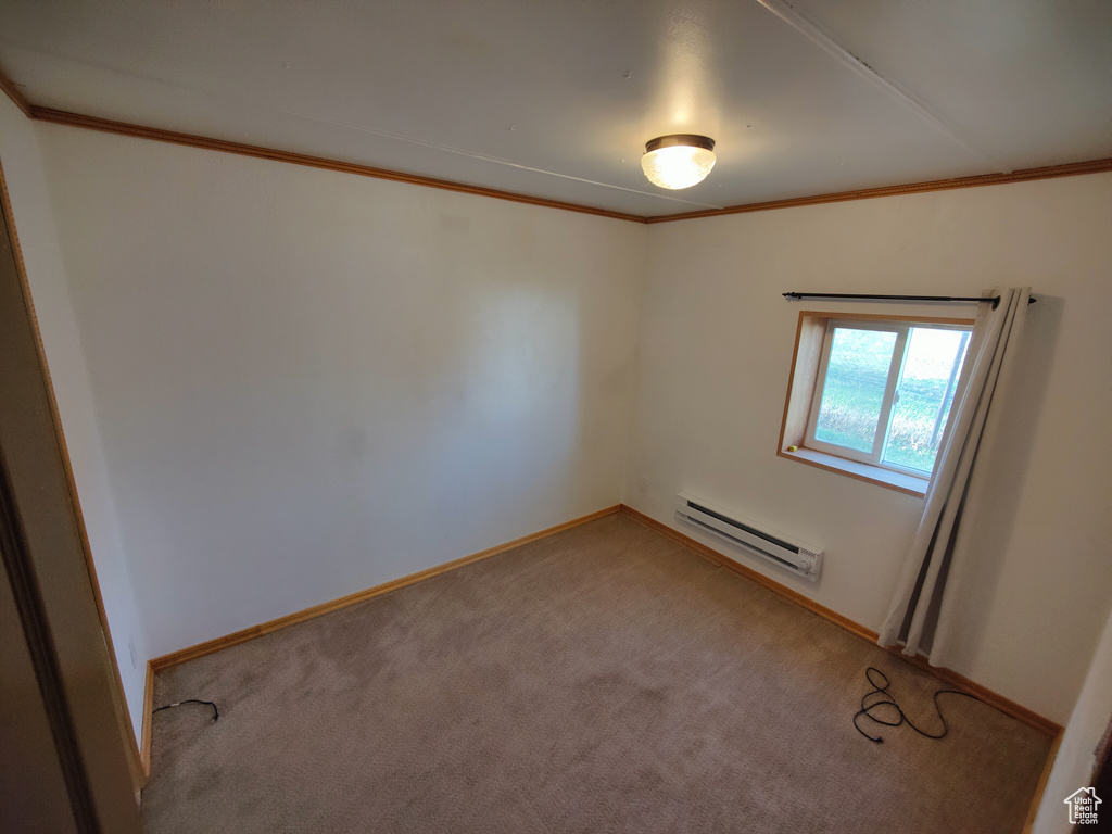 Unfurnished room with light colored carpet, ornamental molding, baseboards, and a baseboard heating unit