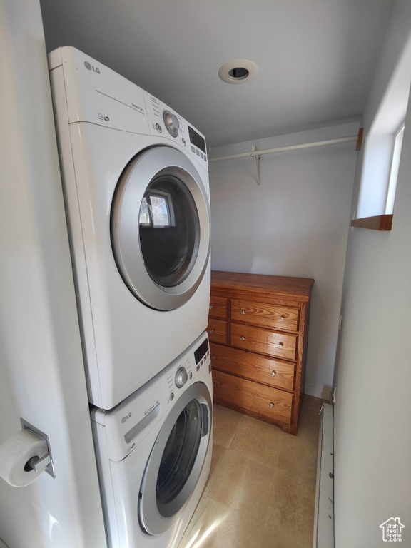Washroom featuring stacked washer / drying machine and laundry area