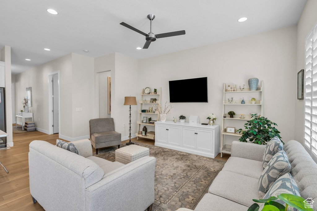 Living room featuring baseboards, ceiling fan, recessed lighting, and light wood finished floors