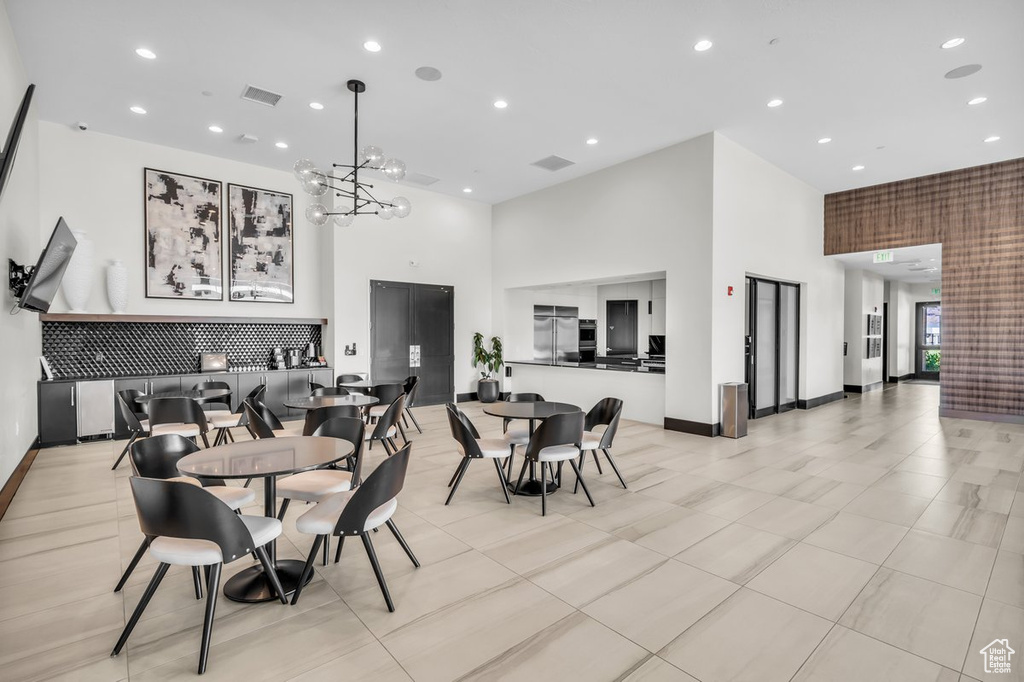 Dining space featuring a towering ceiling, recessed lighting, and visible vents