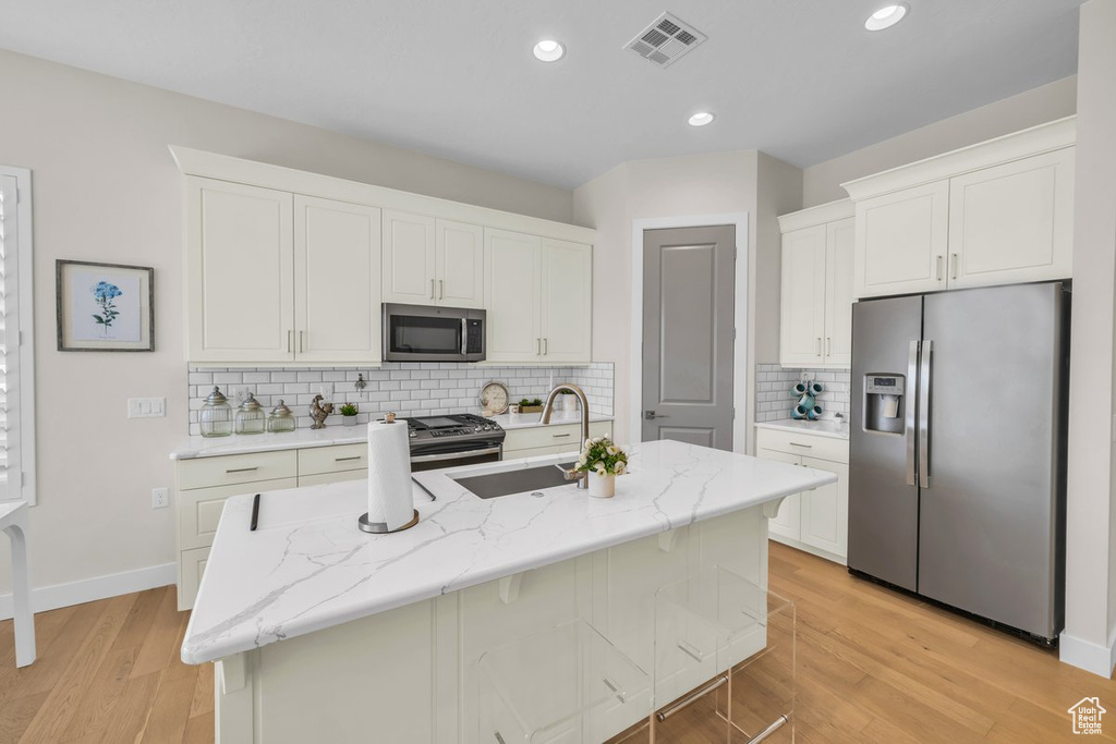 Kitchen featuring a sink, white cabinets, visible vents, and appliances with stainless steel finishes