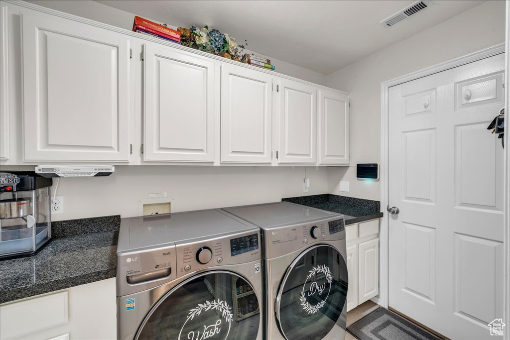 Laundry area featuring cabinet space, separate washer and dryer, and visible vents