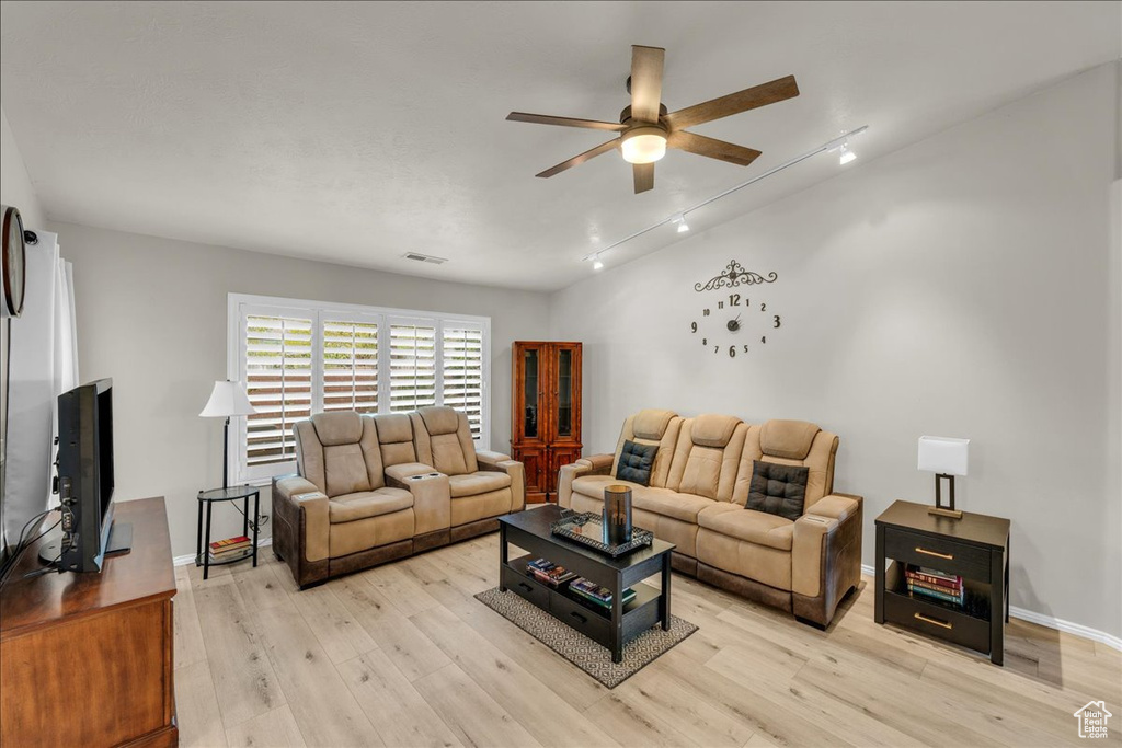 Living room with baseboards, light wood finished floors, visible vents, a ceiling fan, and track lighting