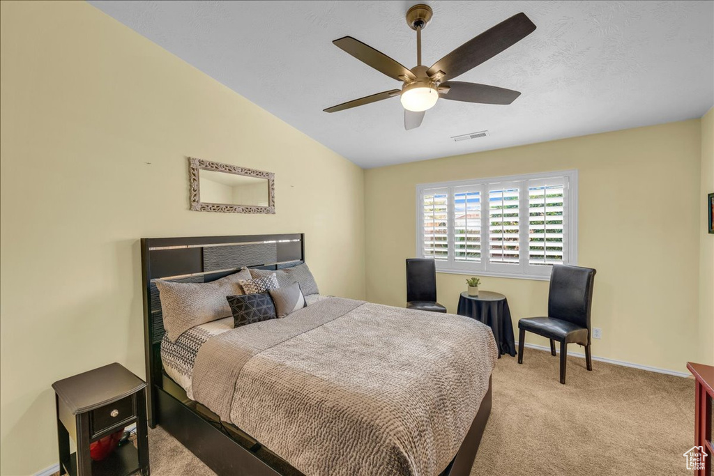 Bedroom featuring vaulted ceiling, baseboards, visible vents, ceiling fan, and carpet