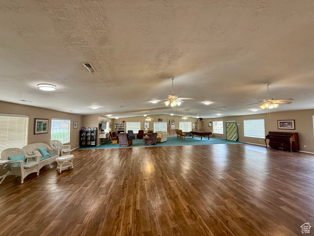 Miscellaneous room featuring visible vents, wood finished floors, ceiling fan, and a textured ceiling