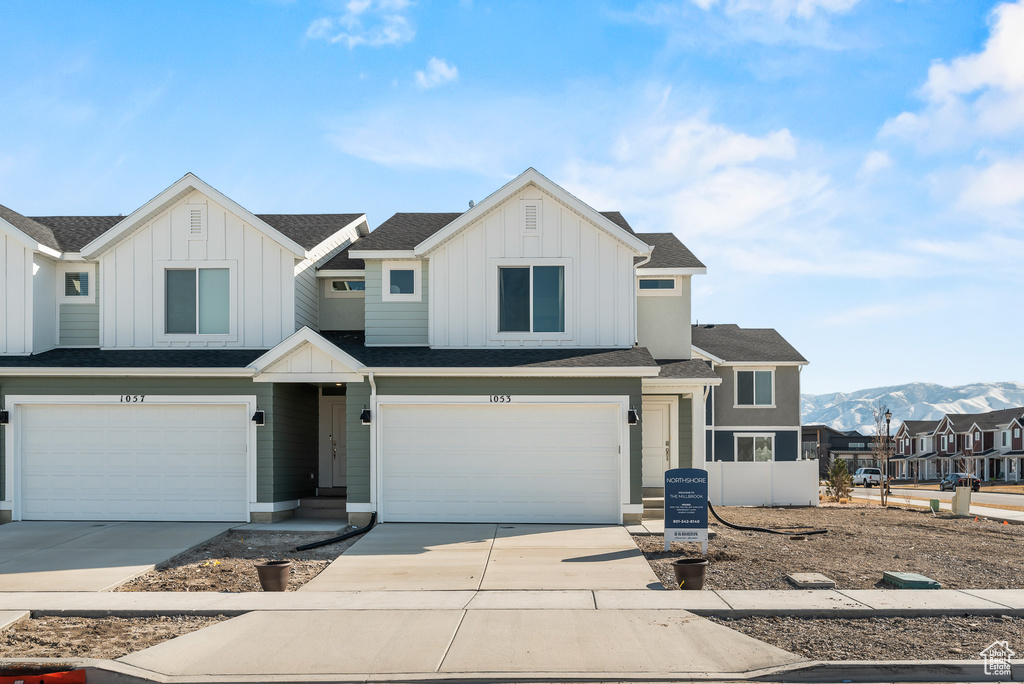 View of front of property with driveway, an attached garage, and board and batten siding