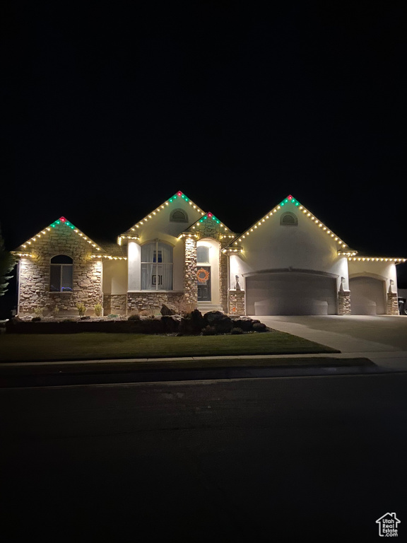 View of front of home featuring stone siding, concrete driveway, a garage, and stucco siding