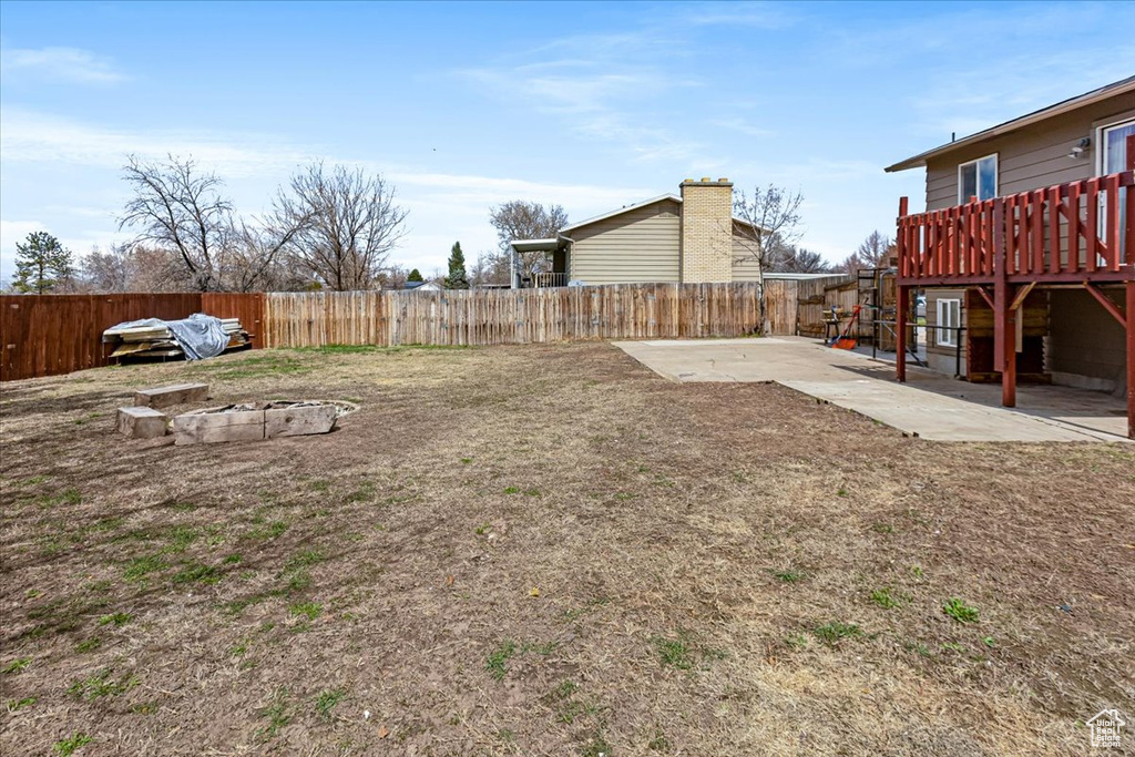 View of yard featuring a fenced backyard, a wooden deck, and a patio area