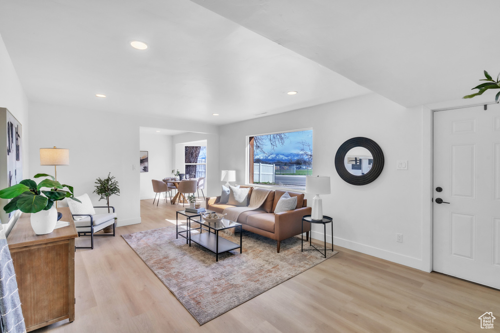 Living area featuring light wood finished floors, baseboards, and recessed lighting